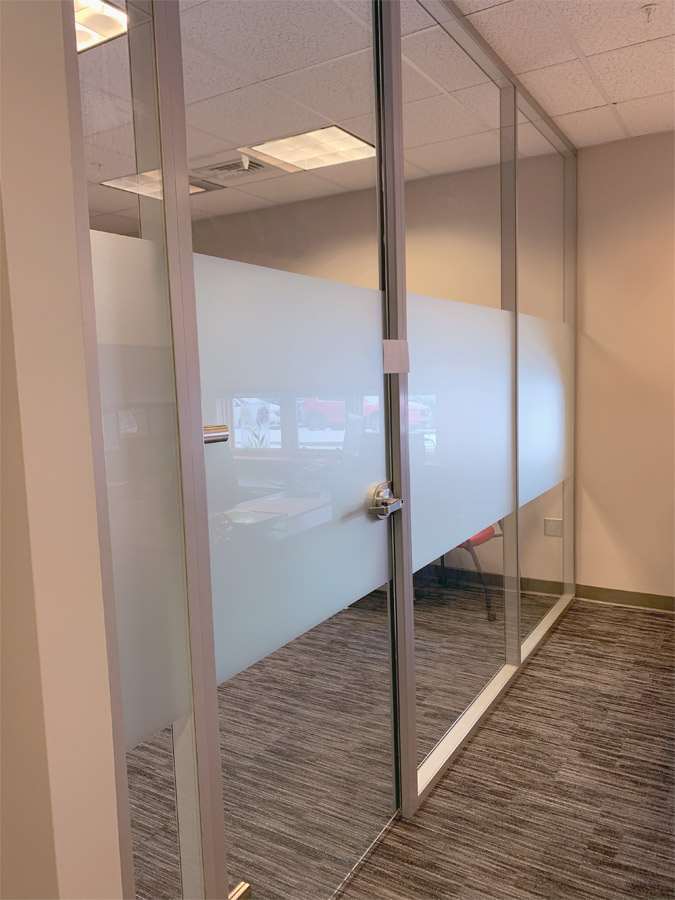 Glass office with sliding glass door and privacy opaque window film