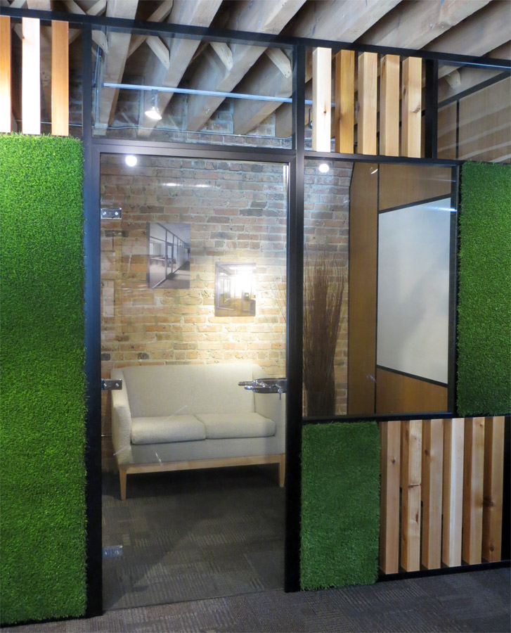 Wood block and green grass wall panels with swing glass door
