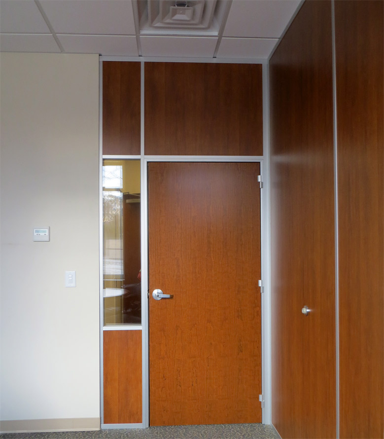 Office with solid wood panels matching door and glass sidelight