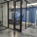 NxtWall glass conference room with fabric side walls and black aluminum frame swing door