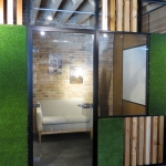 Wood block and green grass wall panels with swing glass door