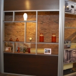 Office with sliding aluminum framed door and open shelf wall
