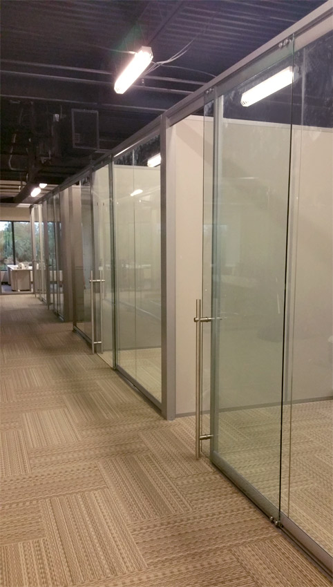 Freestanding glass wall system with locking sliding door pulls