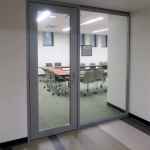 University conference/huddle room glass wall fronts with swing door glass insert