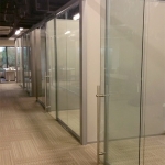 Freestanding glass wall system with locking sliding door pulls