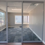 glass wall office with glass slab swing door