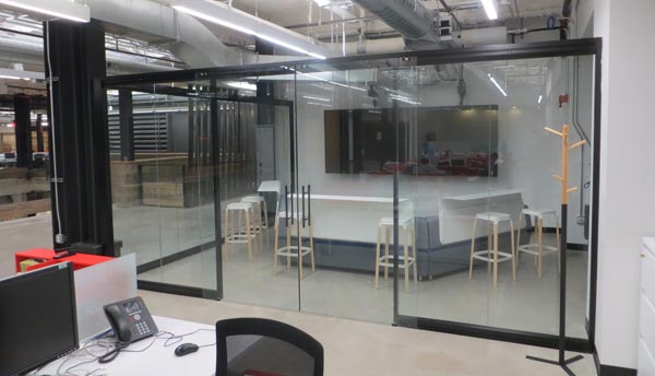 Office space with glass partitions and interior frameless glass door