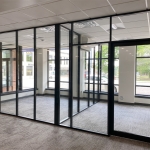 Glass offices with glass sidewalls and black frame color field-fit demountable walls #1643