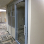 Aluminum framed sliding glass door office with designer 3form wall panels
