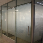 Glass offices with space saving frameless glass sliding doors