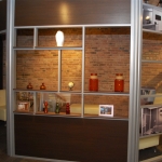 Office with sliding aluminum framed door and open shelf wall #0265